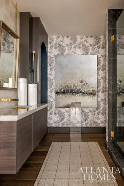 Bathroom with dark wood vanity, marble countertop, patterned wallpaper, and abstract art.