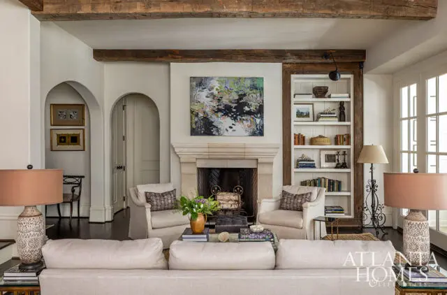 Living room with fireplace, built-in bookshelves, and neutral-toned sofa.