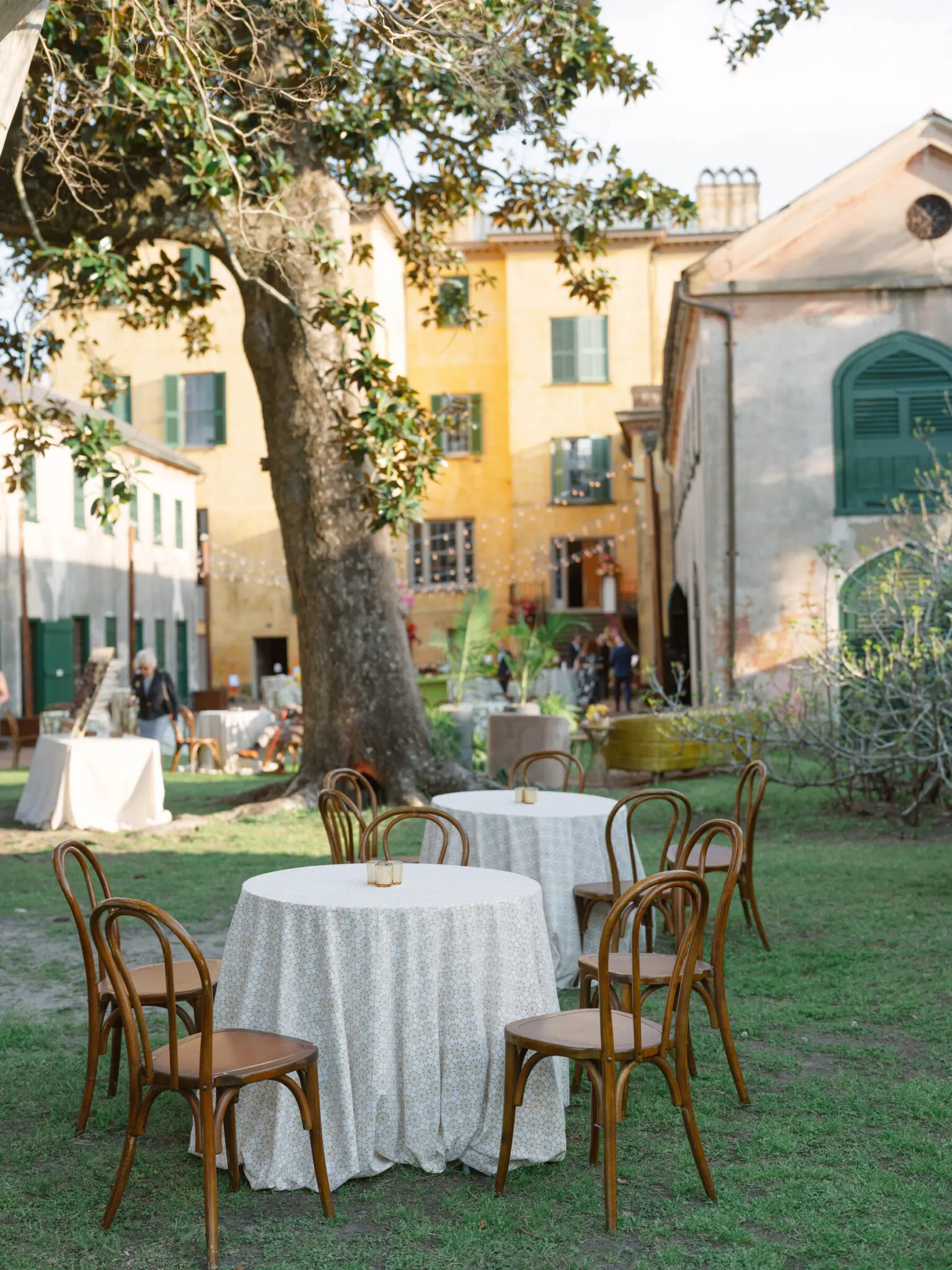 Outdoor courtyard with tables and chairs set up, yellow building in background
