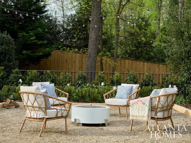 Outdoor seating area with chairs, fire pit, and string lights