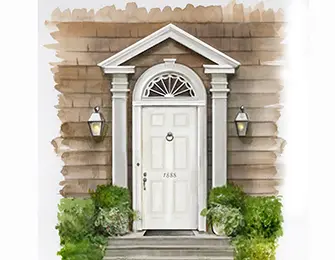 White arched doorway with sidelights and transom, flanked by lanterns and greenery.