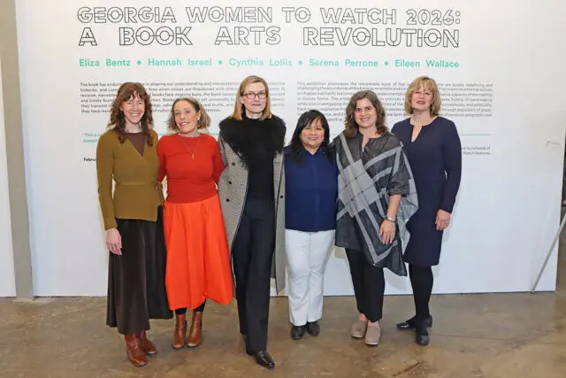 Eliza Bentz, Hannah Israel, Cynthia Lollis, Serena Perrone, and Eileen Wallace stand in front of a wall with text about Georgia Women to Watch 2026: A Book Arts Revolution.