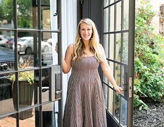 Woman in striped dress standing in an open doorway