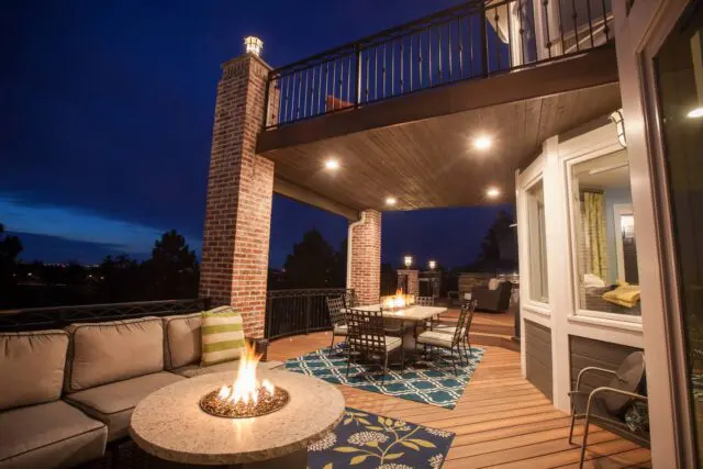 Deck with outdoor seating, dining area, and fire pits at dusk.