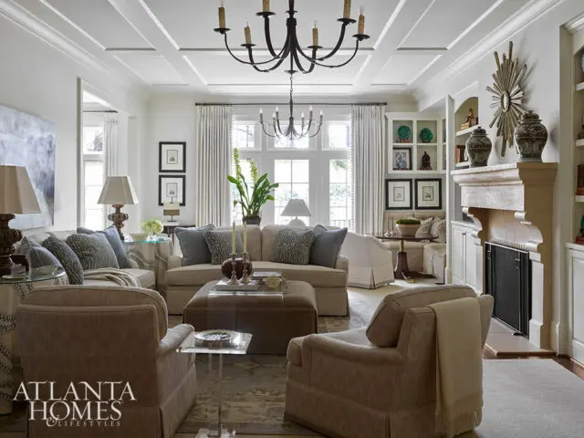 Living room with coffered ceiling, fireplace, and neutral-toned furniture.