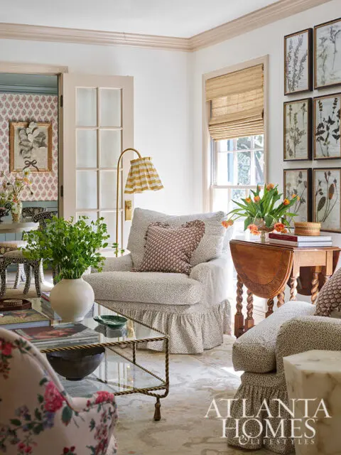 Living room with floral armchair, patterned chairs, botanical prints, and Atlanta Homes &