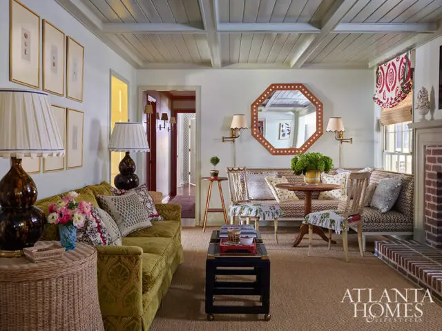 Living room with green sofa, patterned banquette seating, octagonal mirror, and coffered ceiling.