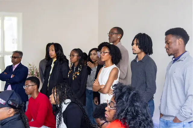 Group of people standing and looking to the left.