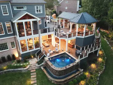 Multi-level deck with hot tub, outdoor kitchen, dining area, and screened porch.