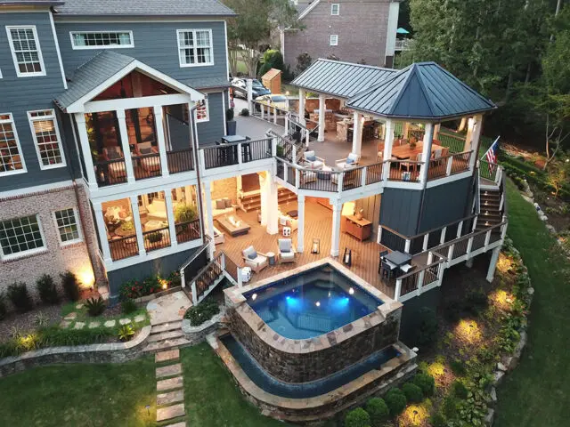 Multi-level deck with hot tub, outdoor kitchen, dining area, and screened porch.