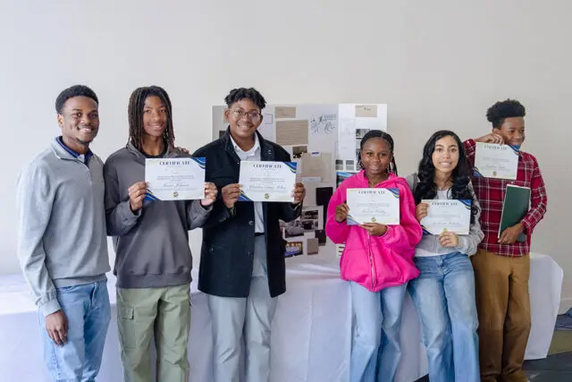 Six young people stand holding certificates.