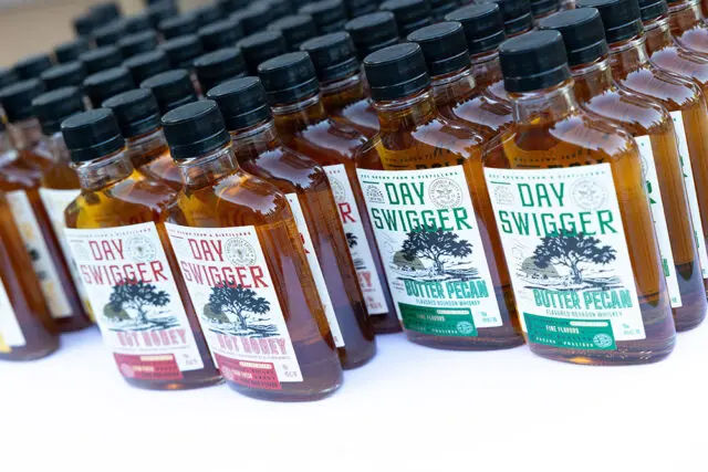 Bottles of Day Swigger flavored bourbon whiskey, including Hot Honey and Butter Pecan