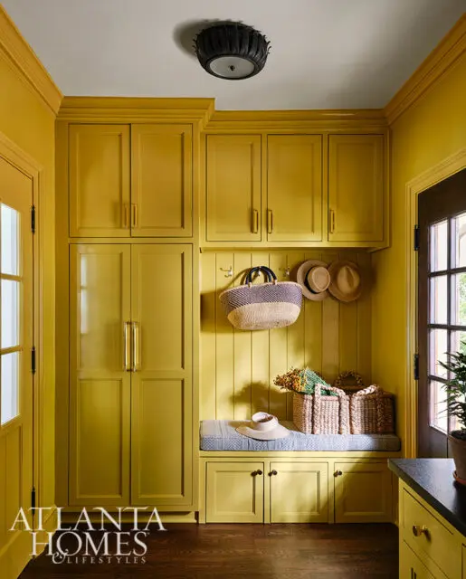 Mudroom with yellow built-in cabinets, bench, and beadboard walls.