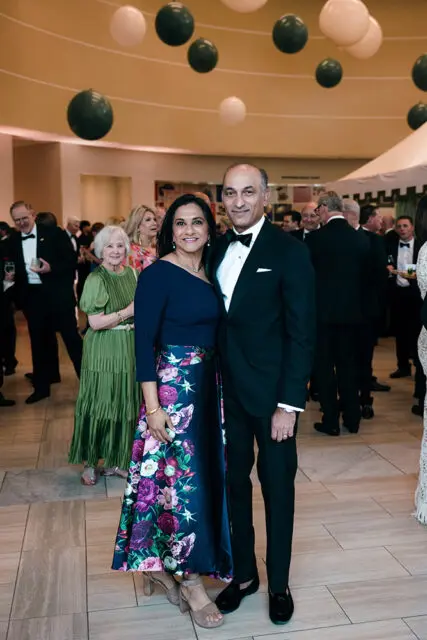 Couple in formal wear at an event with balloons overhead