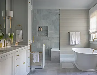 Gray marble bathroom with freestanding tub, double vanity, and built-in linen storage.