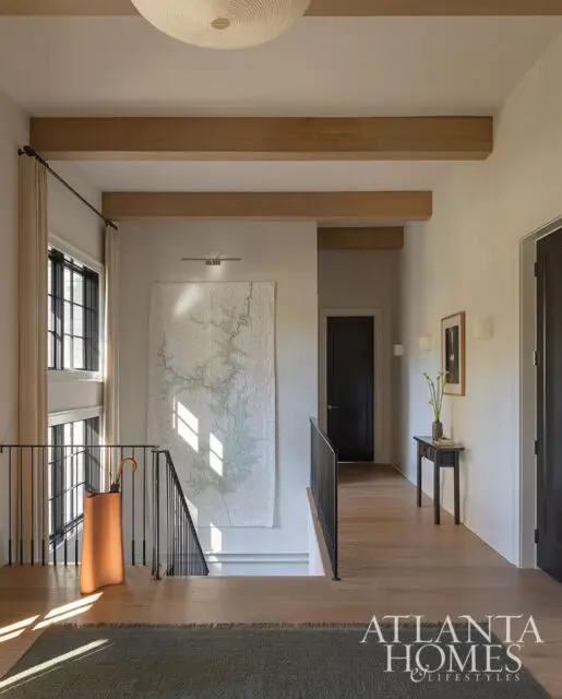 Hallway with wood floors, exposed beams, and a large map artwork.