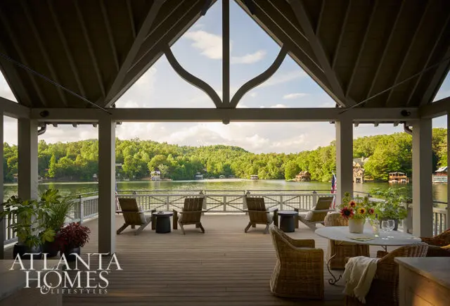 Covered deck with Adirondack chairs overlooking a lake and wooded hills