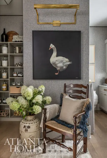 Gray wallpaper with a textured pattern, a large painting of a white goose, and a wooden chair with