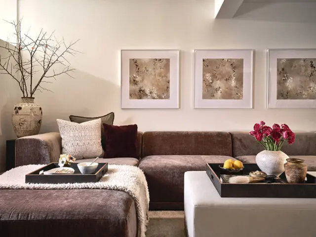 Brown sofa with artwork, pillows, and a tray table.