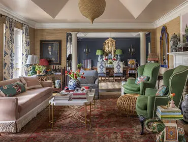 Living room with patterned wallpaper, blue and green accents, and a decorative lantern.