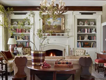 Living room with built-in bookshelves, a fireplace, and a large chandelier.