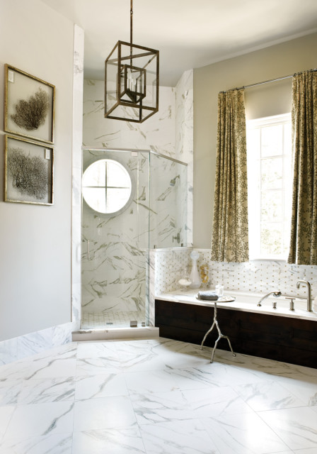 Luxury bathroom with marble tile floors and shower, dark wood bathtub surround, and a geometric pendant light fixture.