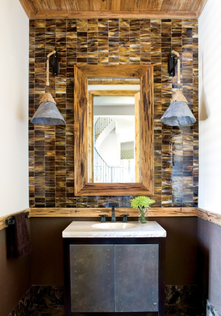Bathroom with iridescent brown tile backsplash, rustic wood mirror, metal-front vanity, and rope-accented sconces.