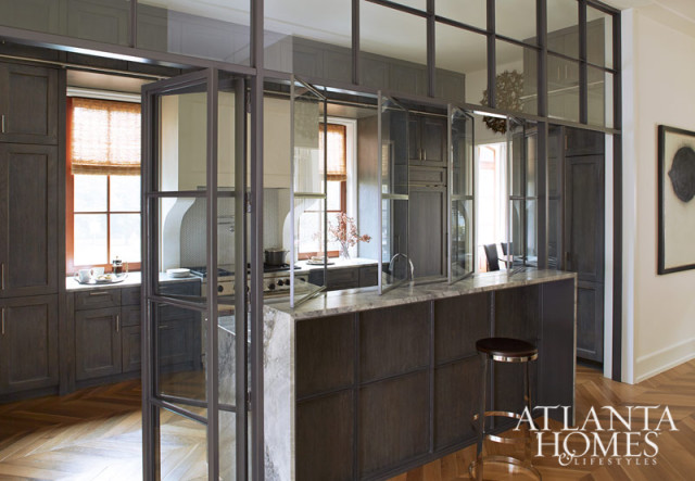 Dark wood kitchen with marble island and herringbone wood floors.