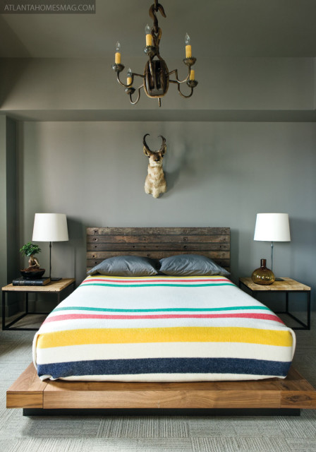 The colors of the blanket on the master bed in the city may look straight out of the groovy “70s, but they harken back to a couple centuries before that. In the 1770s, Stanton explains, fishermen would trade these traditional wool blankets to Native Americans in exchange for furs and other goods. Here, its vivid stripes help temper the deep gray walls and the rustic touches found throughout the space. Rugged platform bed, Stanton Home Furnishings.