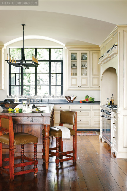 A masterfully designed kitchen by Connecticut-based Crane Woodworking combines the best of old and new: barstools from Holland & Co. and an antique chandelier found at Ma Maison.