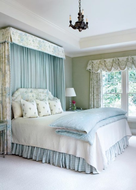 Angela had the walls in the master bedroom upholstered in a soft wool fabric. She took cues from the greens, blues and whites in the garden to choose the bedroom“s quiet color scheme.