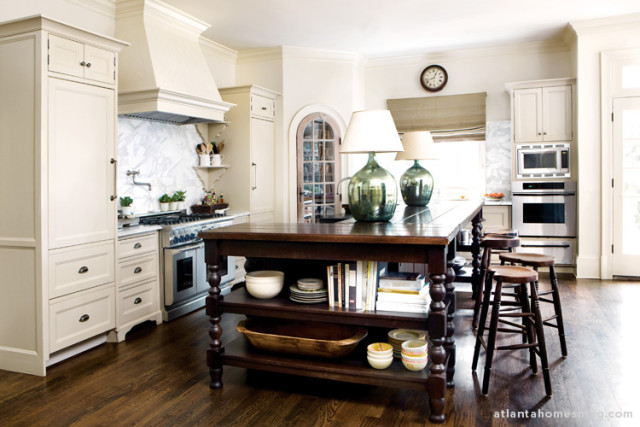 Calcutta gold marble countertops with painted and stained cabinetry make up the design of the newly renovated kitchen. The island was designed by Tammy Connor Interior Design. Barstools, Robert Hill Antiques, Birmingham. Paint color on cabinetry, Benjamin Moore HC-82.
