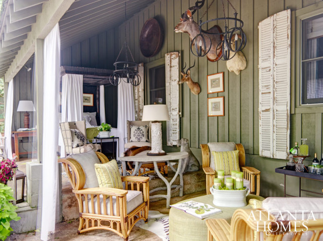 To foster a feeling of intimacy in the bunk house's narrow sleeping porch, Lynn Monday created a guest-worthy retreat by draping the space with panels in the same fabric as its rustic-chic canopy bed. A separate seating area also feels at one with nature thanks to a soothing color palette and textural materials.