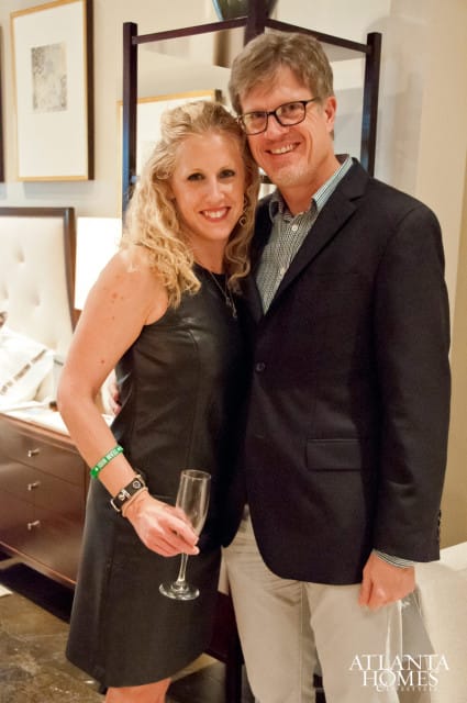 Laura Scholz and Tim Long pose for a portrait, Scholz wears a black leather dress and Long wears a navy blazer over a patterned shirt.