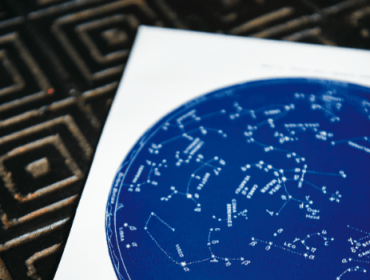 Blue star chart with constellations labeled, on white paper