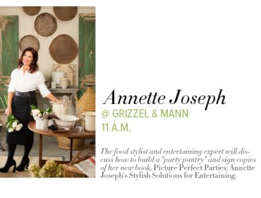 Annette Joseph, food stylist and entertaining expert, standing in a room with rustic decor, holding a bouquet of white roses.