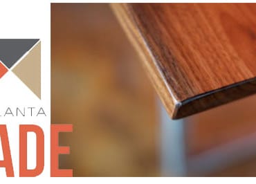 Logo with "ATLANTA MADE" text and a graphic of four colored triangles. To the right, a close-up of a polished wooden surface.