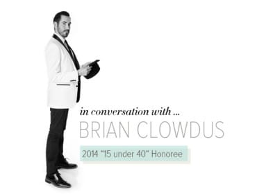Man in a white tuxedo jacket and black pants holding a black hat, with text "in conversation with... BRIAN CLOWDUS 2014 "15 under 40" Honoree"