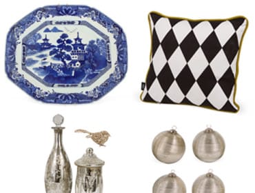 Four decorative items: a blue and white chinoiserie platter, a black and white diamond pattern pillow, two mercury glass bottles, and four silver striped ornaments.