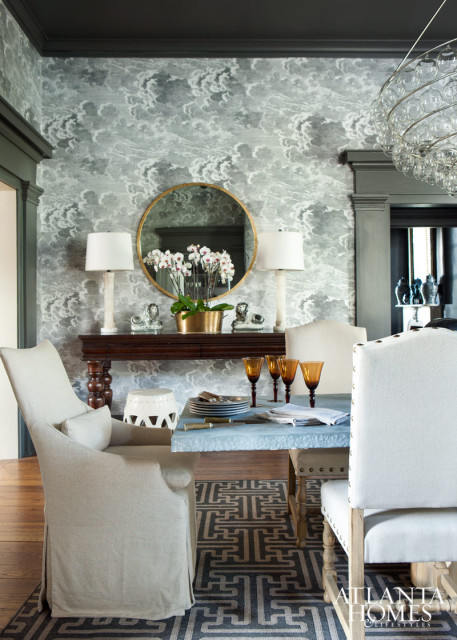 An entrancing Cole & Son wallpaper in the dining room depicts stormy skies.