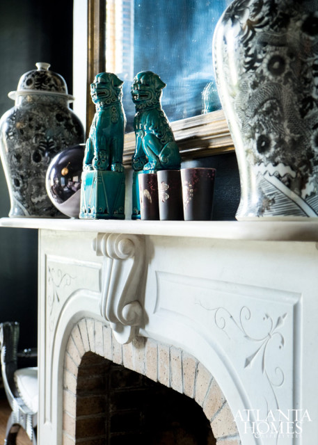 The velvety seating and diamond-pattern rug are foils for more traditional objects, such as foo dogs and ginger jars. The fireplace is one of five in the home.