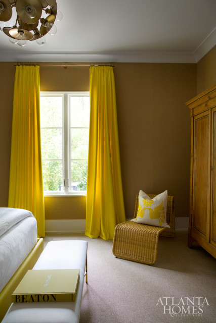The sunny guest room on the home’s lower level remains bright, thanks to bursts of yellow that pop against textured walls, and a polished bathroom that positively shines.