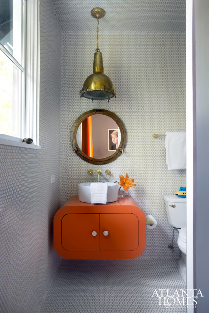 Bold punches of orange filter through Holden’s bathroom and bedroom, where unused space above his built-in bunk beds was transformed into a rock-climbing room Lee admits is fun for all ages.