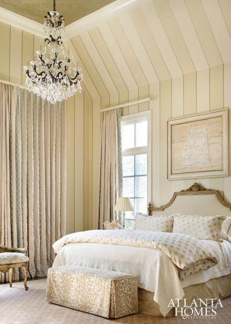 Subtle patterns in the fabrics and striped walls add interest to the monochromatic color scheme in the soothing master retreat. A contemporary painting by Raul Diaz, represented by TEW Galleries, helps anchor the showstopping space.