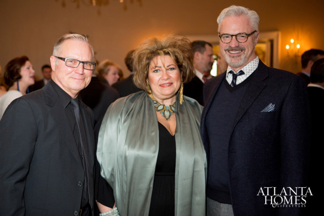 John Howard, Susan Ferrier, and Bobby McAlpine pose for a photo at an event. Howard wears a black suit and tie, Ferrier wears a sage green wrap and statement necklace, and McAlpine wears a navy blazer over a v-neck sweater.