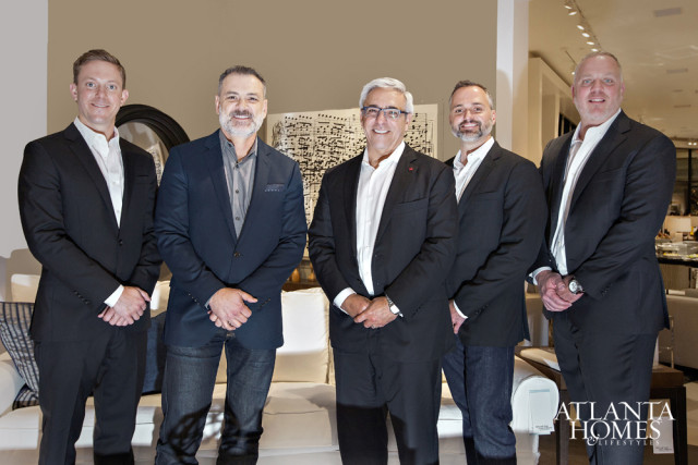 Five men in suits stand in front of a cream-colored wall and a large piece of abstract art. A logo for Atlanta Homes & Lifestyles is visible in the lower right corner.