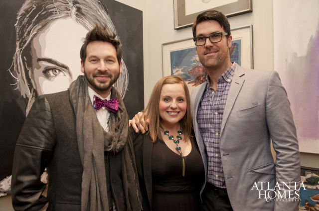 Three people posing in front of artwork. Atlanta Homes & Lifestyles logo in lower right.