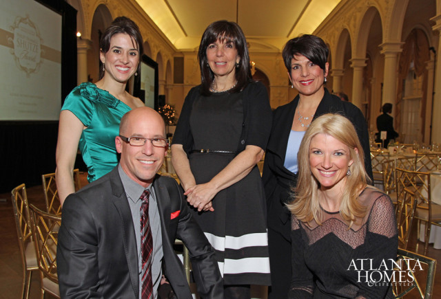 Five people posing for a photo at an event. A man in a suit is in the foreground, with four women standing behind him. A logo for Atlanta Homes & Lifestyles is visible in the lower right corner.