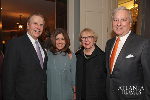 Four people posing for a photo indoors. The two men wear suits and ties, and the two women wear dresses. A logo for Atlanta Homes & Lifestyles is visible on the right side of the image.