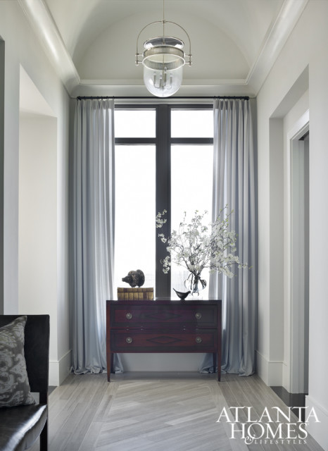 The gallery marble floor is inlaid on the diagonal to suggest a runner. A chest by Niermann Weeks, antique accessories and window treatments soften a tall window.